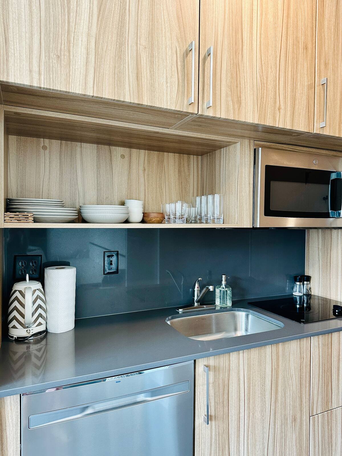 Modern kitchenette with wood cabinets and stainless appliances