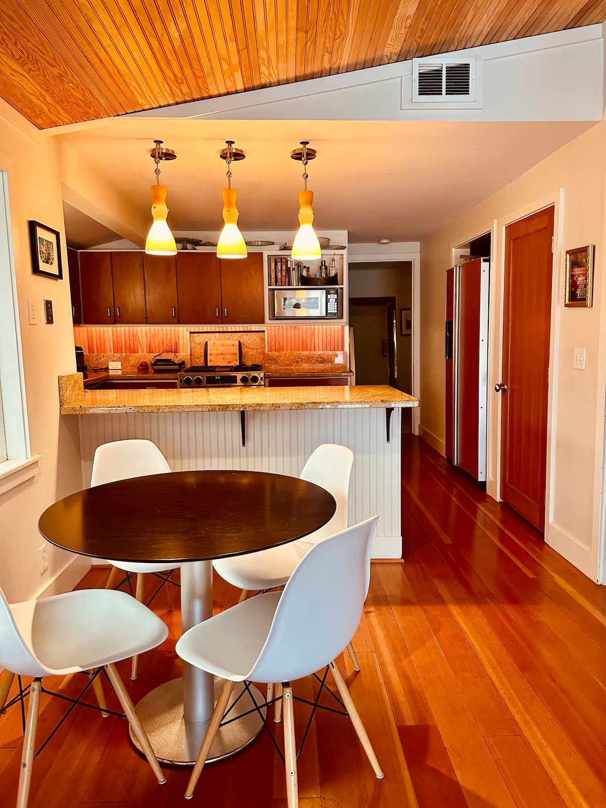 Round dining table with Eames chairs and pendant lights