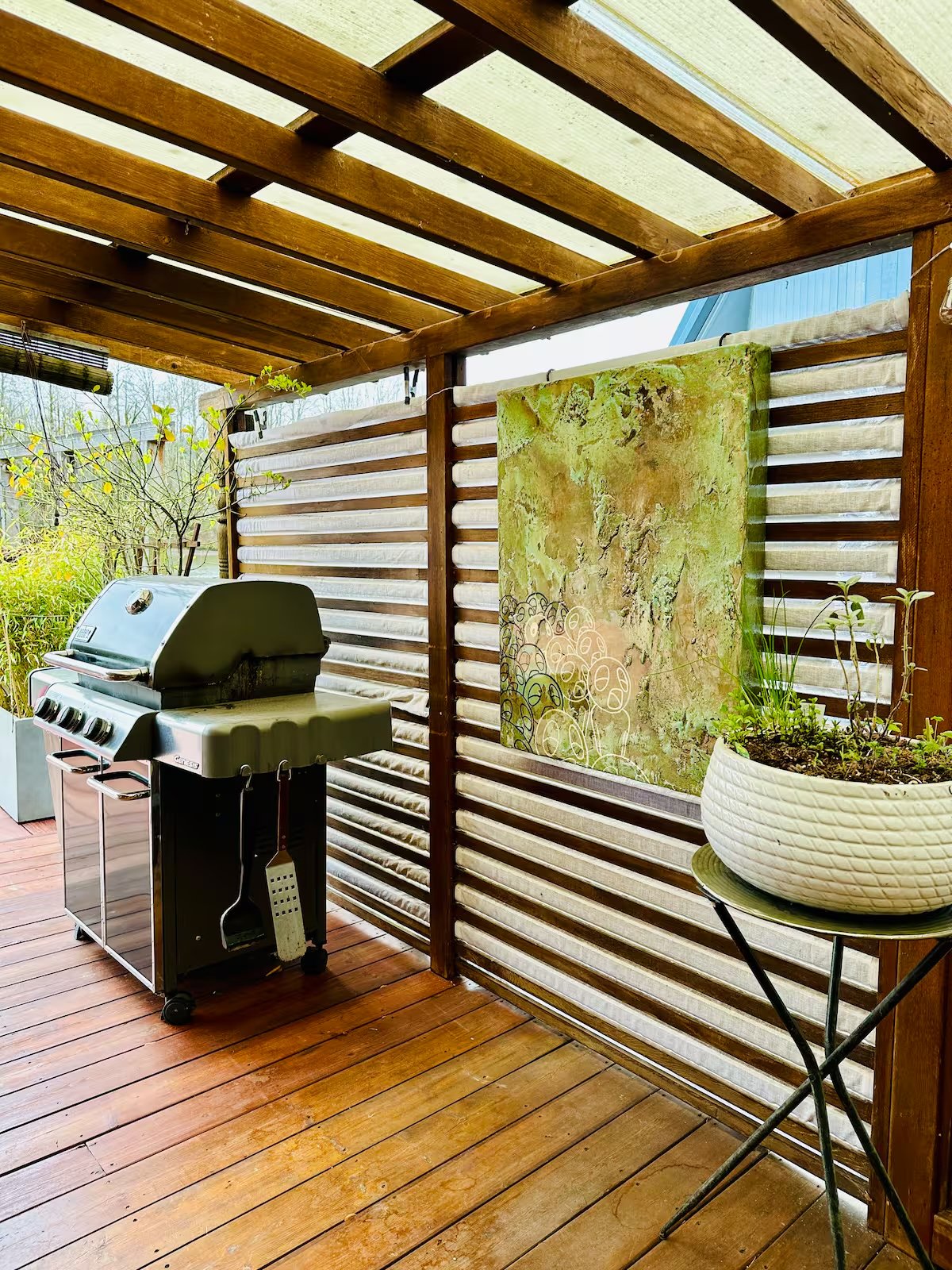 Outdoor grill area with art on slatted fence